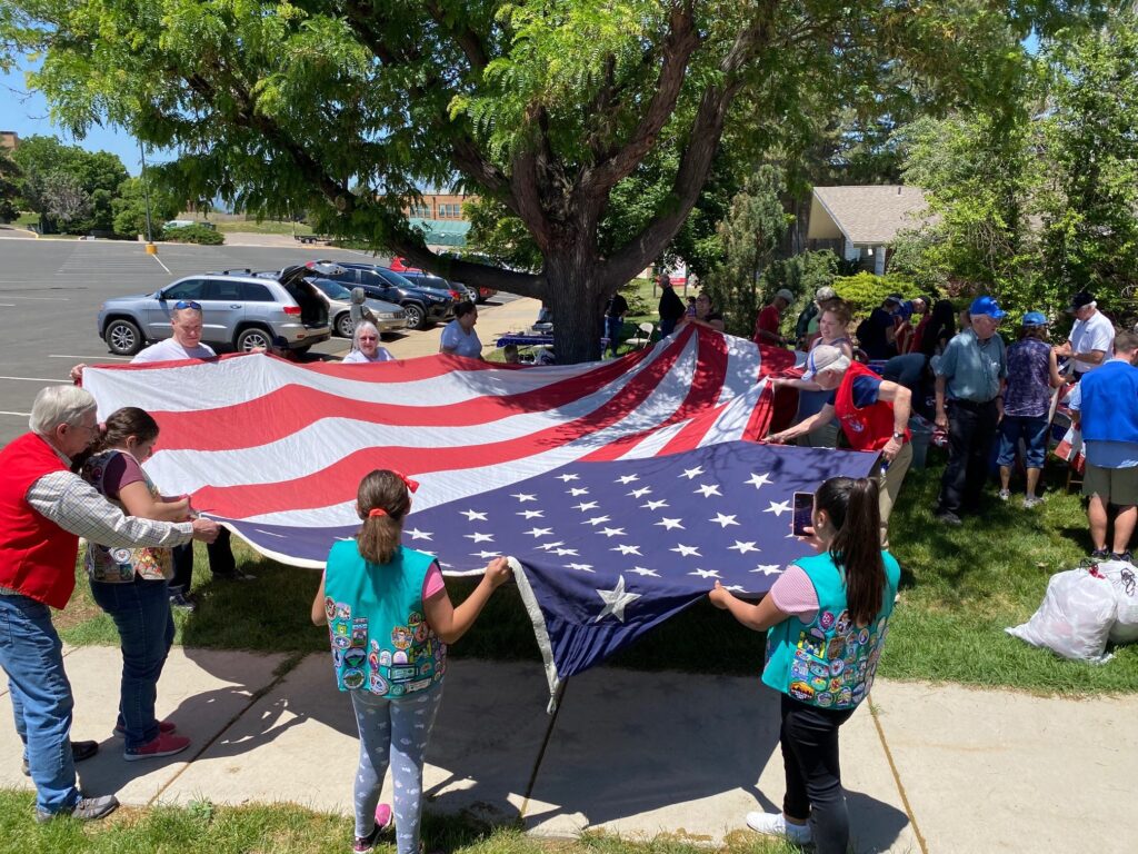 Community members spread out a large flag in preparation of retiring it.